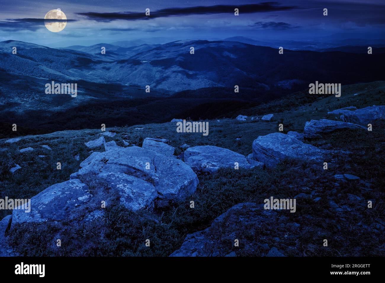 mountain landscape with white boulders on the hillside at night. wonderful countryside scenery in full moon light Stock Photo