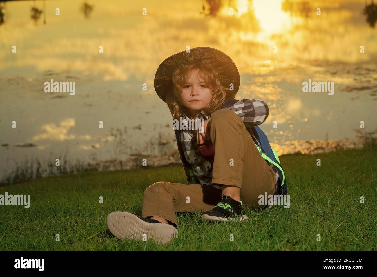 Kid with binoculars hiking at nature. Little explorer. Outdoor recreation and adventures with kids. Child tourist on sunny countryside background Stock Photo