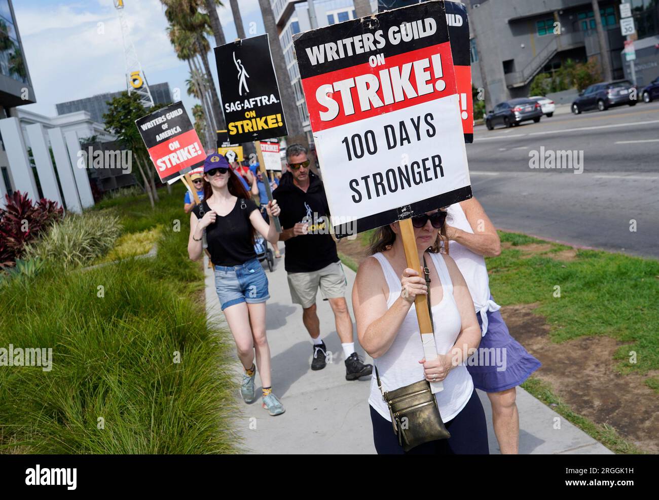 WGA member Emiliana Dore carries a sign on a picket line outside Netflix  studios on Wednesday, Aug. 9, 2023, in Los Angeles. The Hollywood writers  strike reached the 100-day mark today as