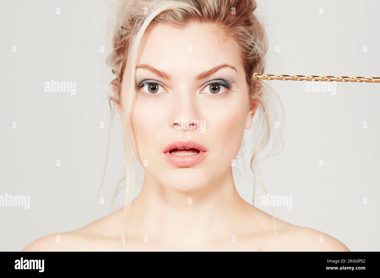 Young woman with drill pressed against her head Stock Photo Alamy