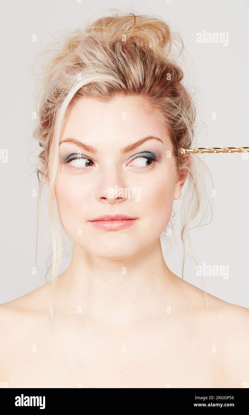 Young woman with drill pressed against her head Stock Photo Alamy