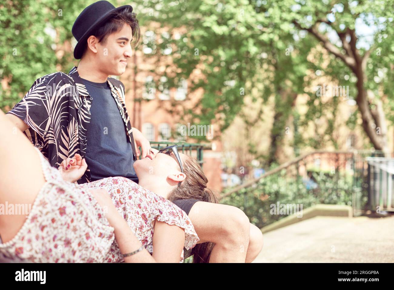 Teenage girl lying in boyfriend's lap at park Stock Photo Alamy