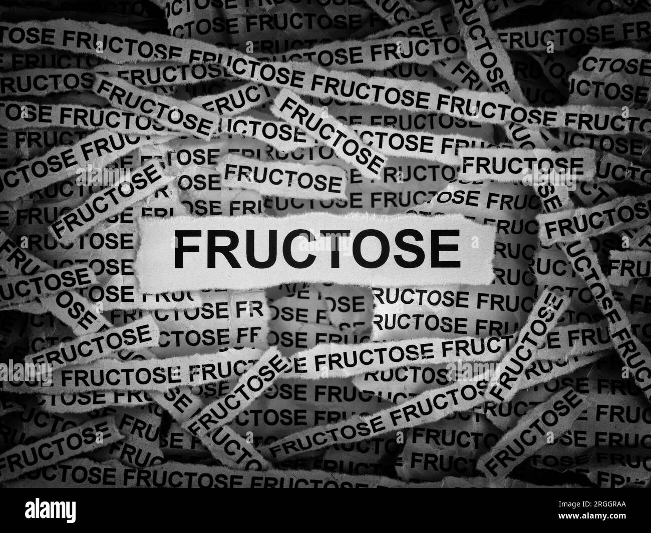 Strips of newspaper with the words Fructose typed on them. Black and white. Close up. Stock Photo