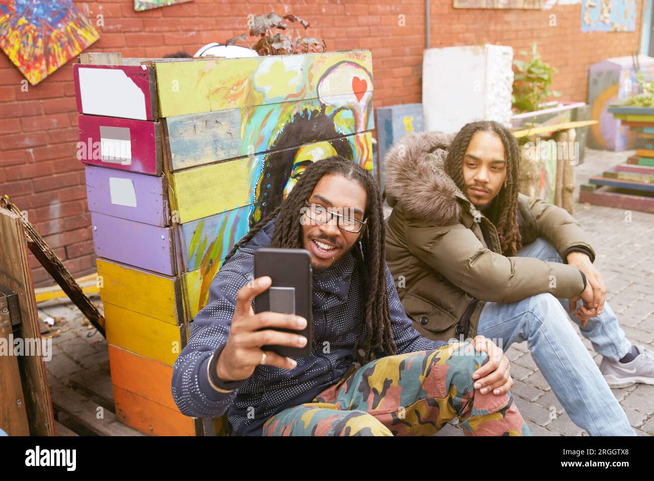 Young man taking selfie with friend Stock Photo