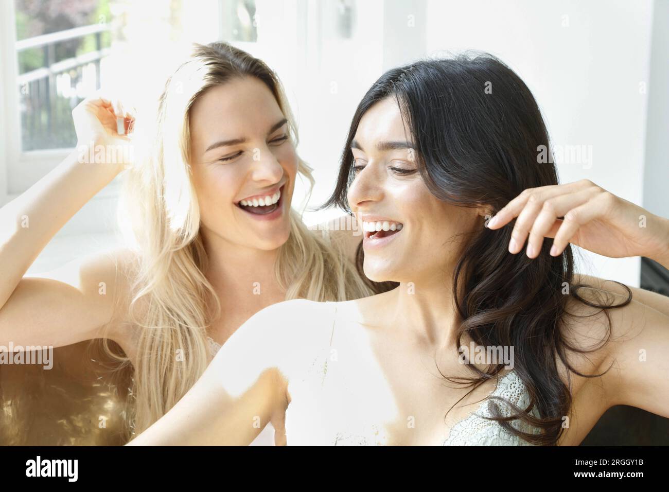 Young women sitting in bath tub Stock Photo Alamy