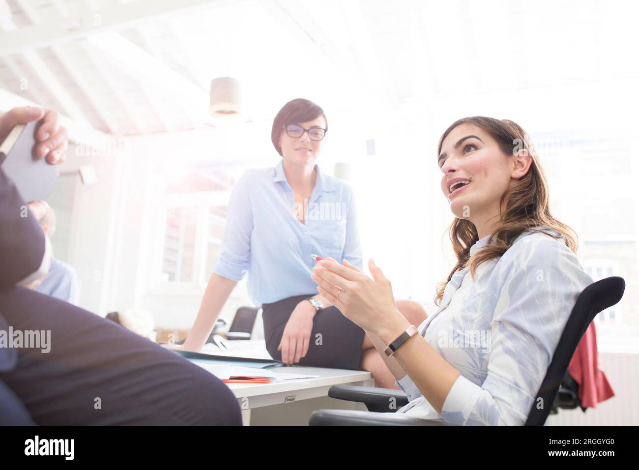 Young businesswoman talking to colleagues in office Stock Photo