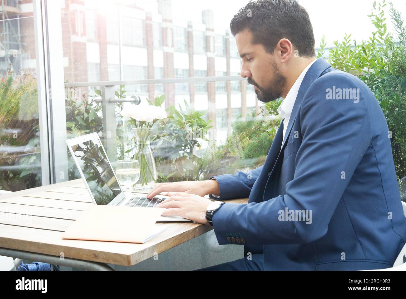 Businessman using laptop at restaurant table Stock Photo