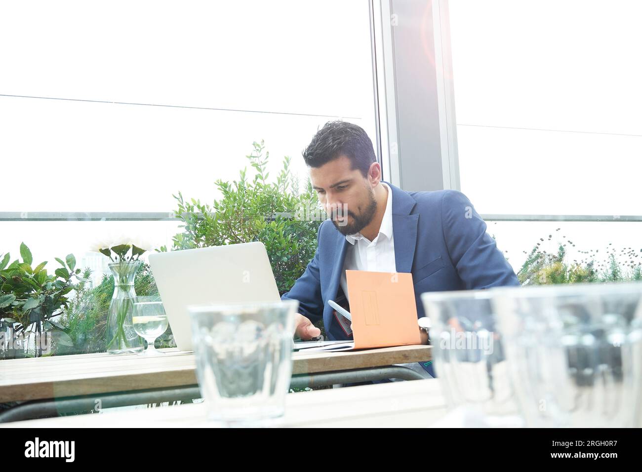 Businessman using laptop at restaurant table Stock Photo