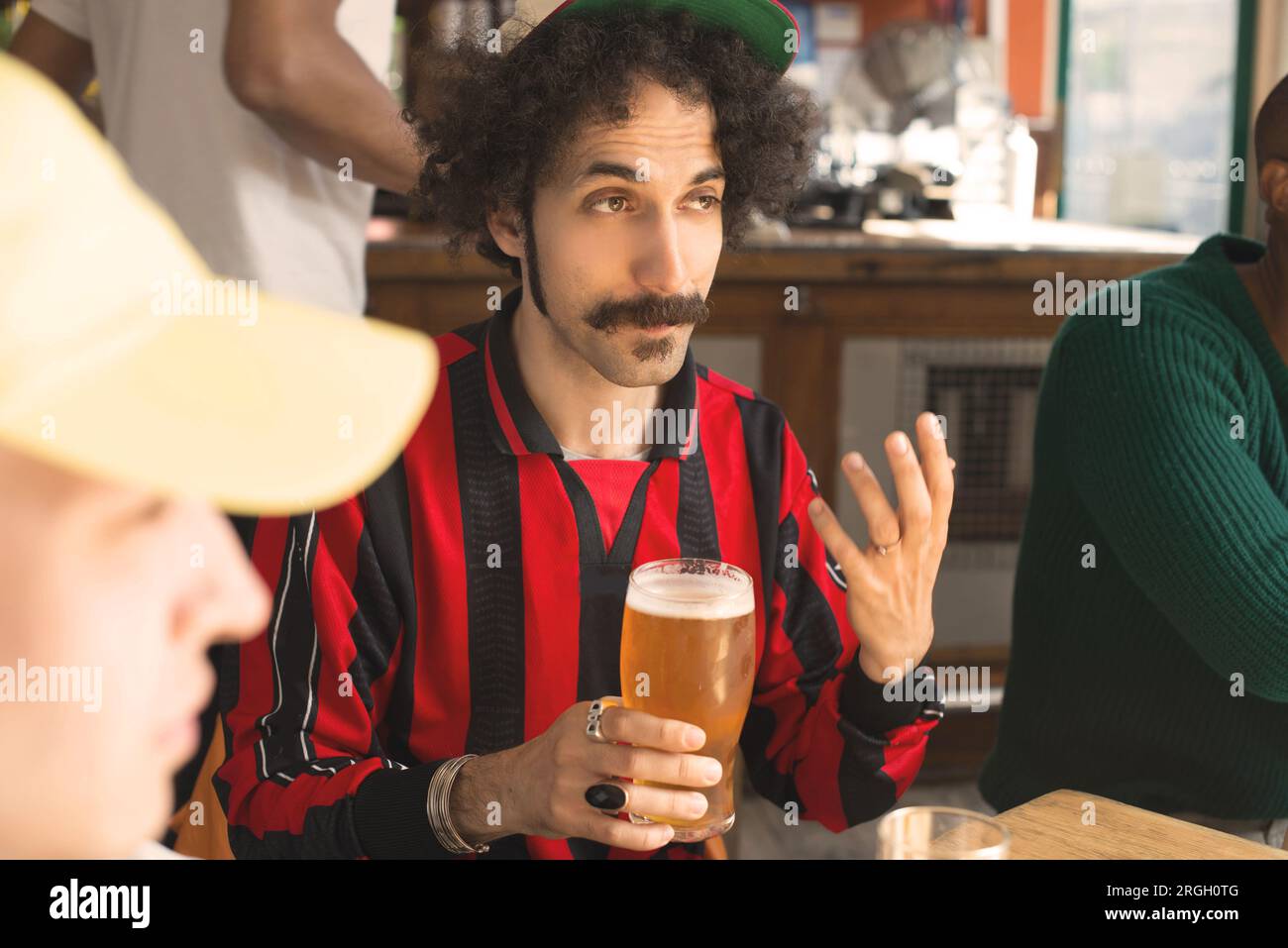 Man with a mustache holding a beer glass at a bar Stock Photo
