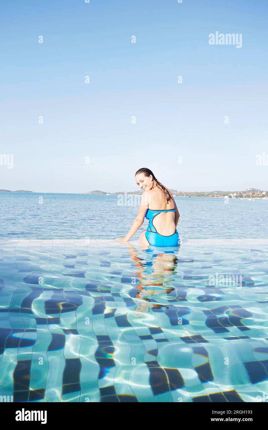 Young woman sitting poolside in Ko Samui, Thailand Stock Photo