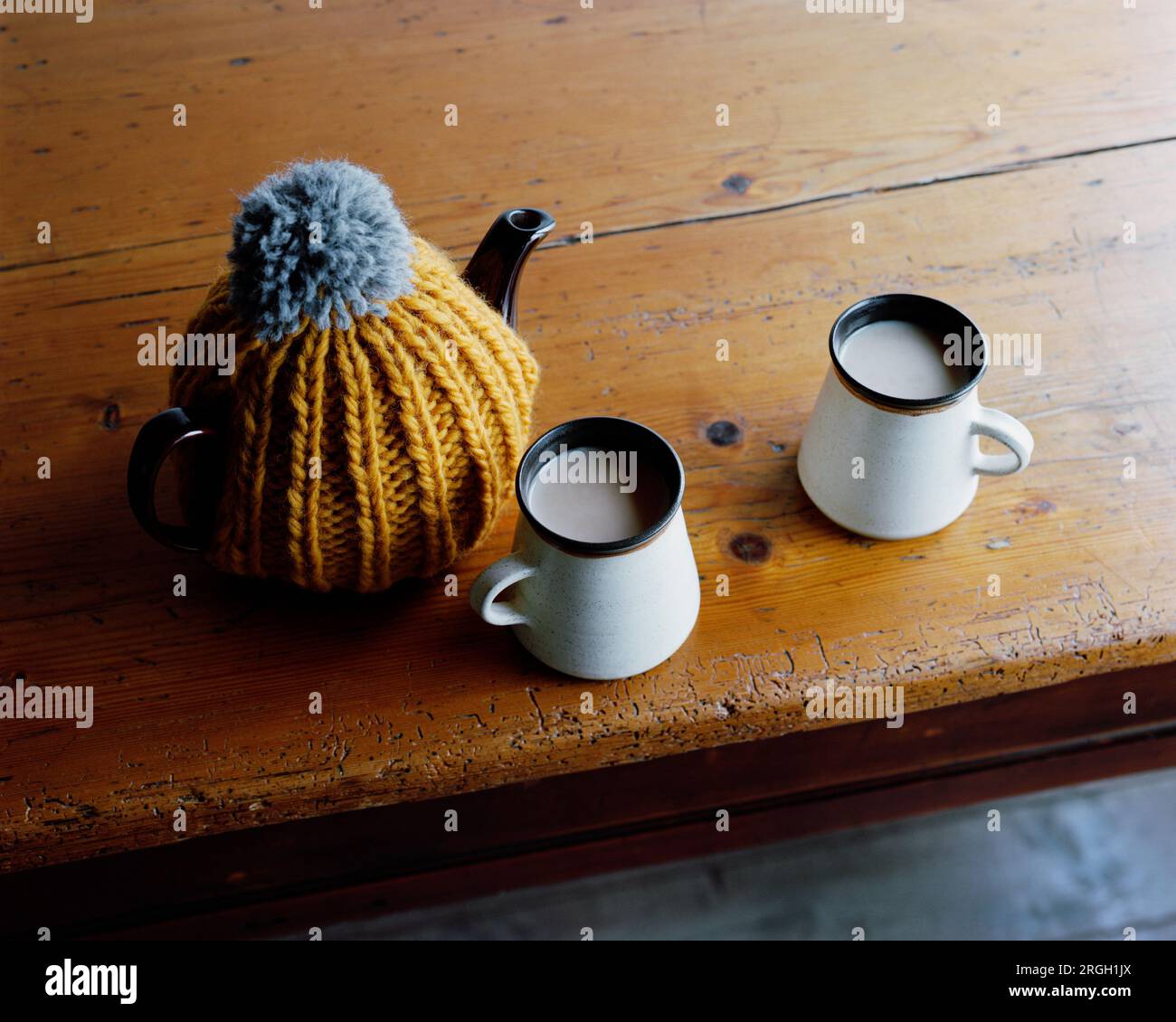 Tea cups and kettle with tea cozy Stock Photo Alamy