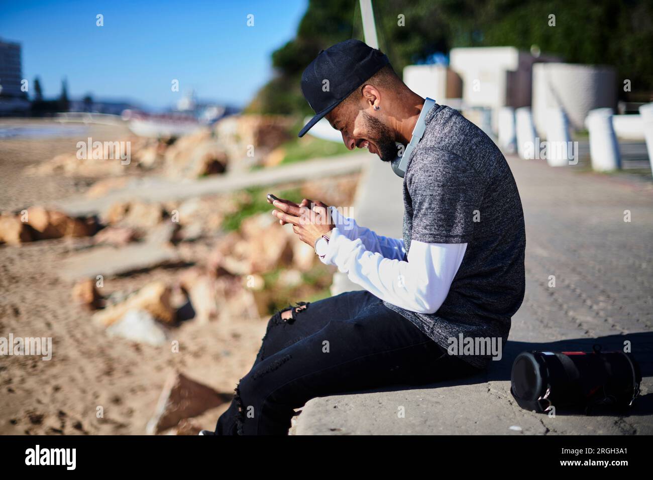 Young man with smart phone by beach Stock Photo