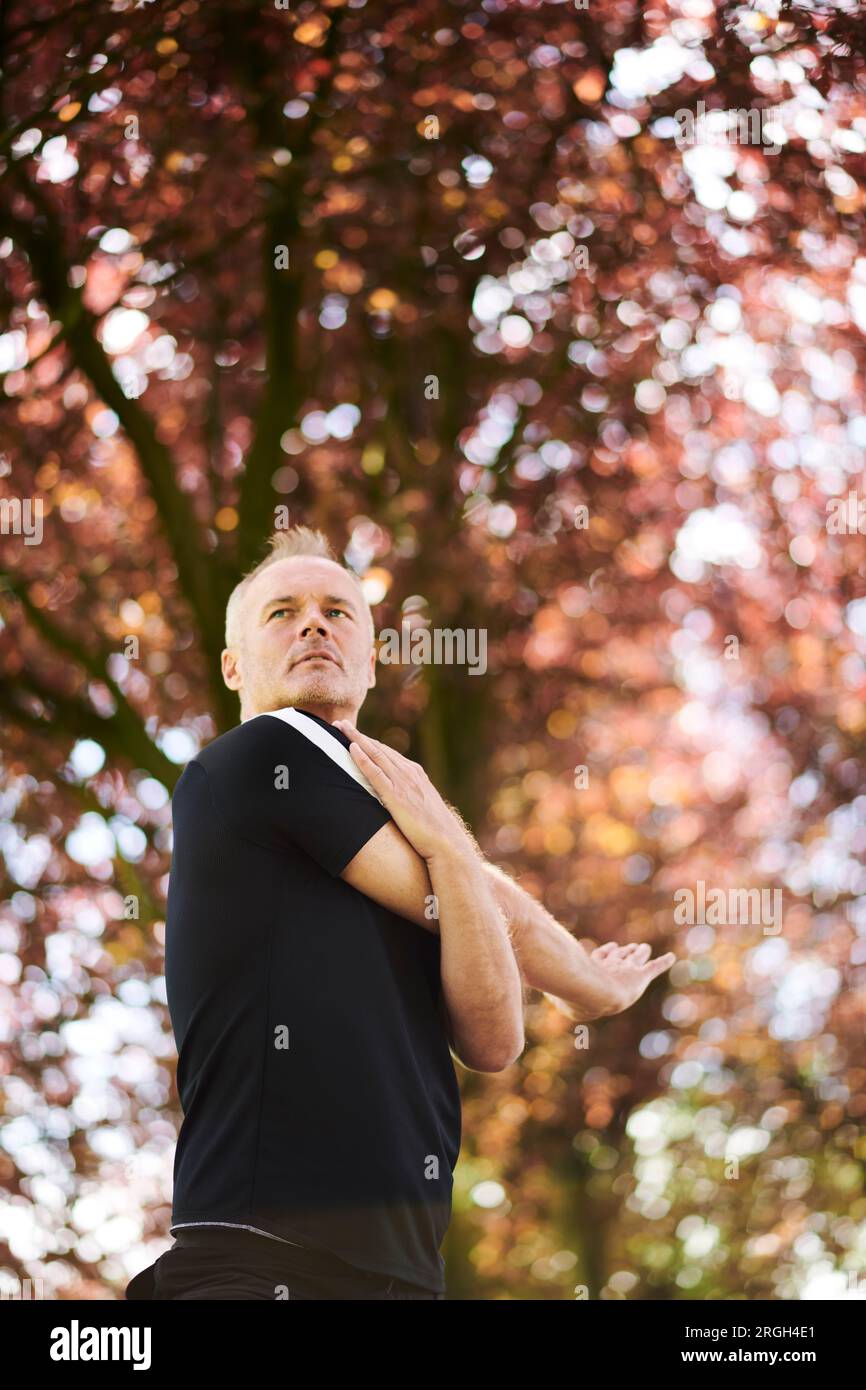 Mature man practicing yoga in park Stock Photo