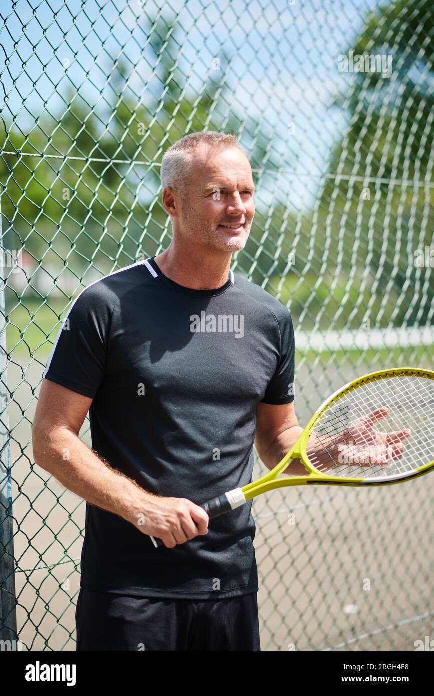 Mature man holding tennis racket Stock Photo