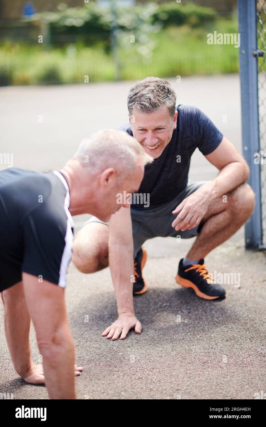 Mature men doing push-ups Stock Photo
