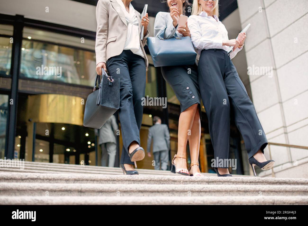 Businesswomen walking down staircase Stock Photo