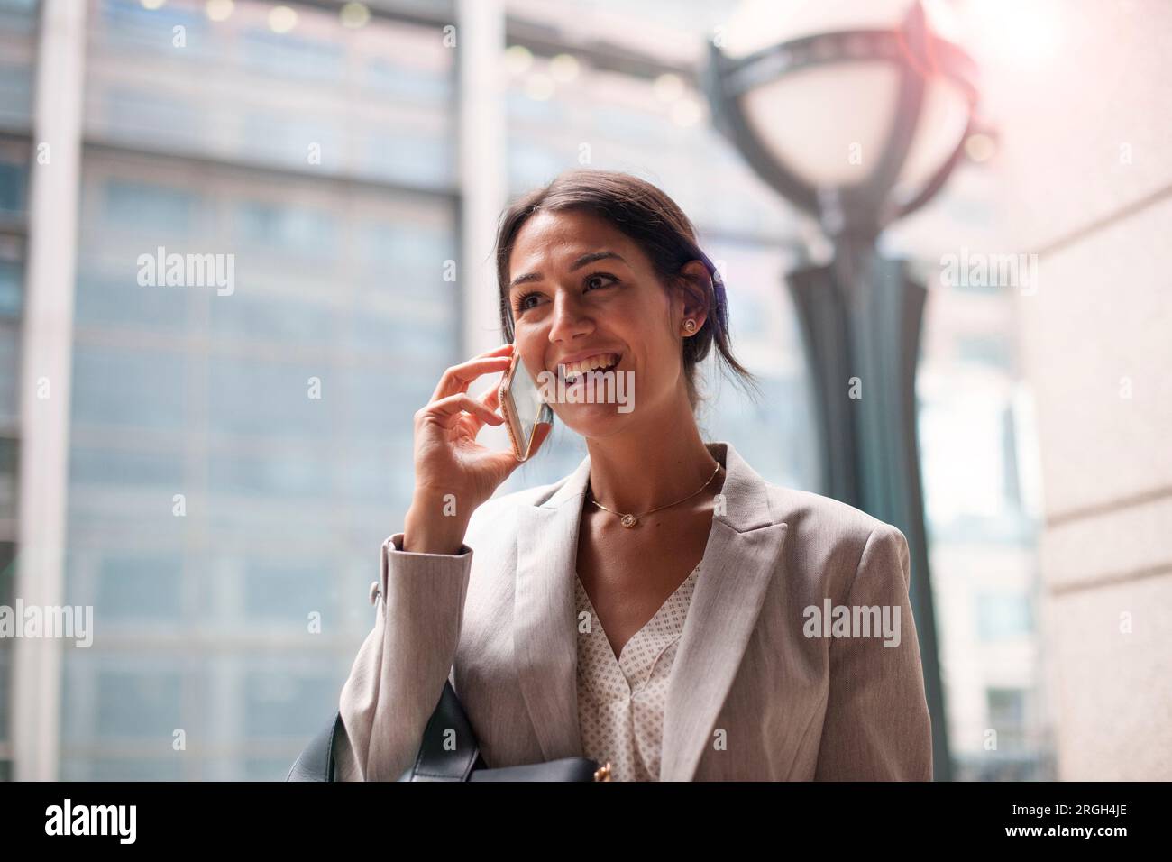 Young woman smiling while on phone Stock Photo