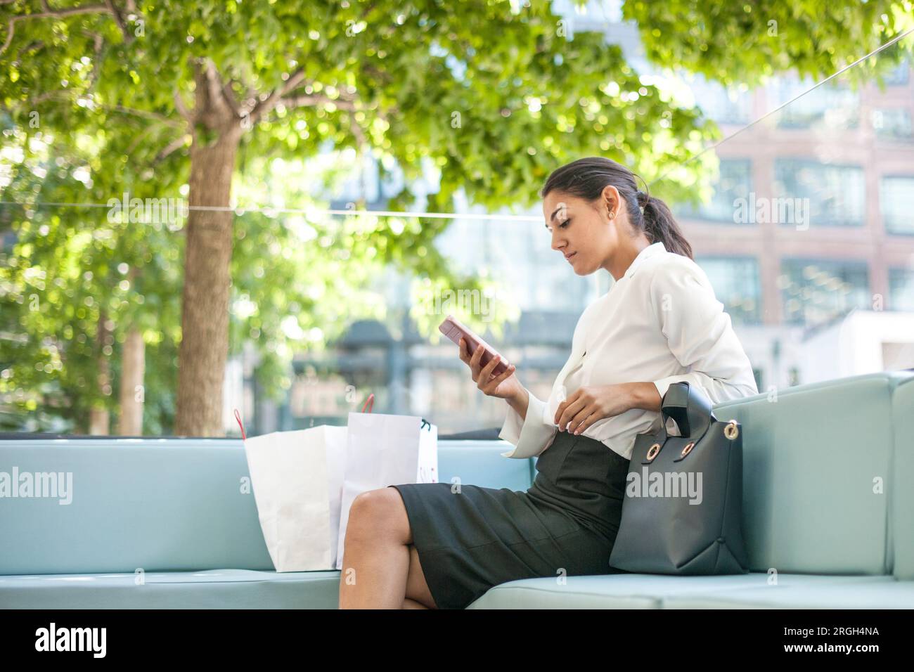 Businesswoman using smart phone on sofa Stock Photo