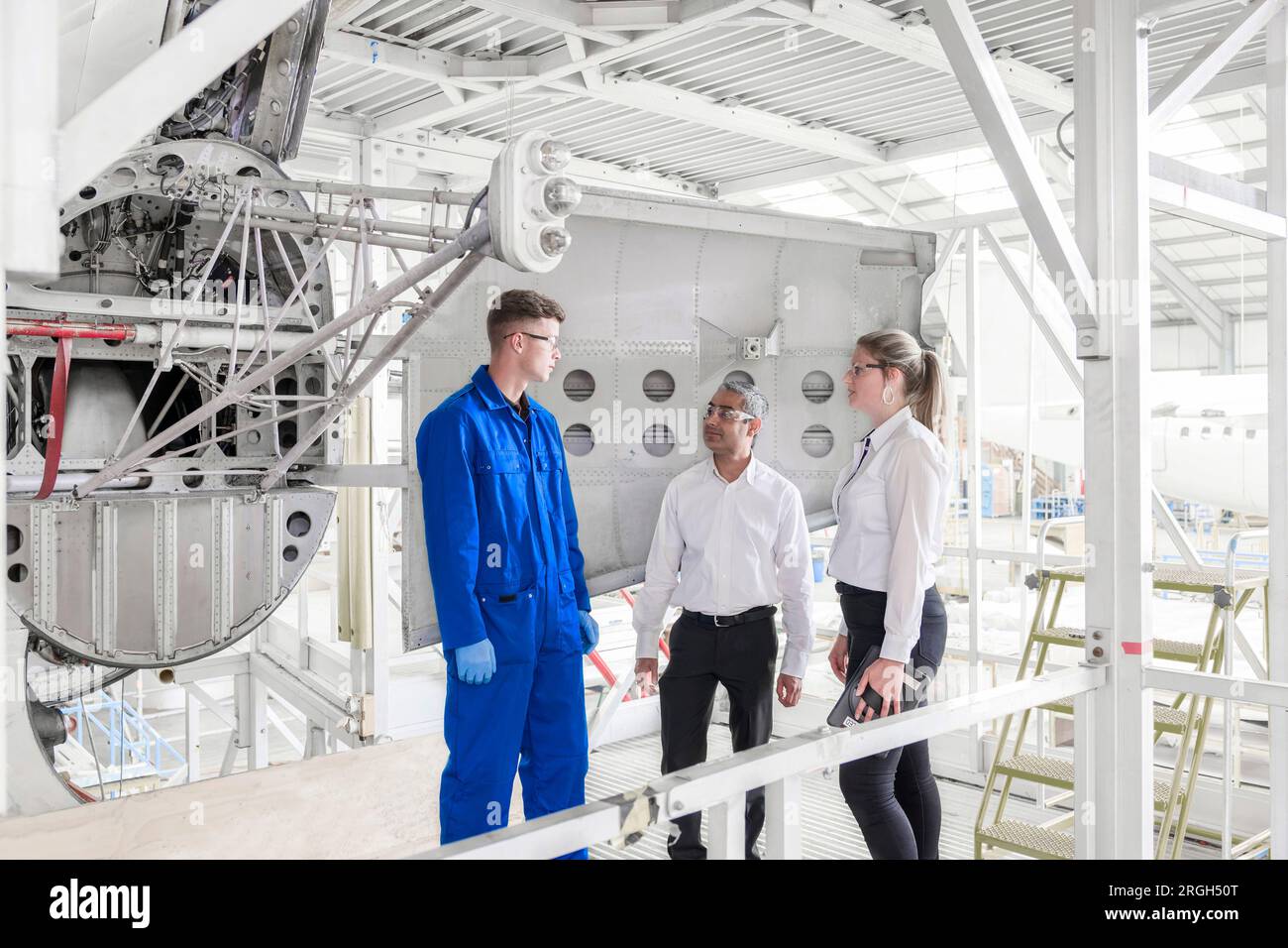 Workers with digital tablet in airplane hangar Stock Photo