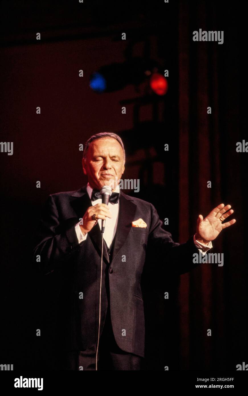 Frank Sinatra in performance, 1982. Photograph by Bernard Gotfryd . Francis Albert Sinatra was an American singer and actor. Nicknamed the "Chairman of the Board" and later called "Ol' Blue Eyes", he is regarded as one of the most popular entertainers of the mid-20th century. Sinatra is among the world's best-selling music artists with an estimated 150 million record sales.  Born to Italian immigrants in Hoboken, New Jersey, Sinatra began his musical career in the swing era . Stock Photo