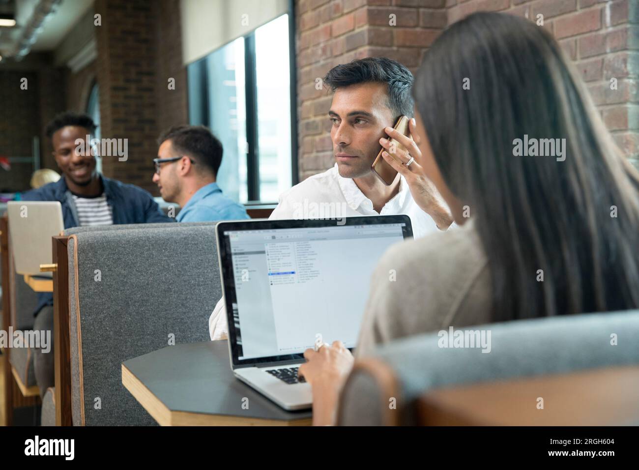 Businessman using smart phone during meeting Stock Photo