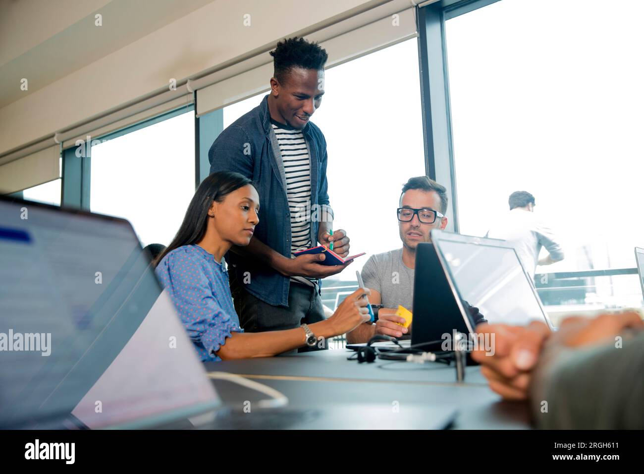 Colleagues using laptops during meeting Stock Photo