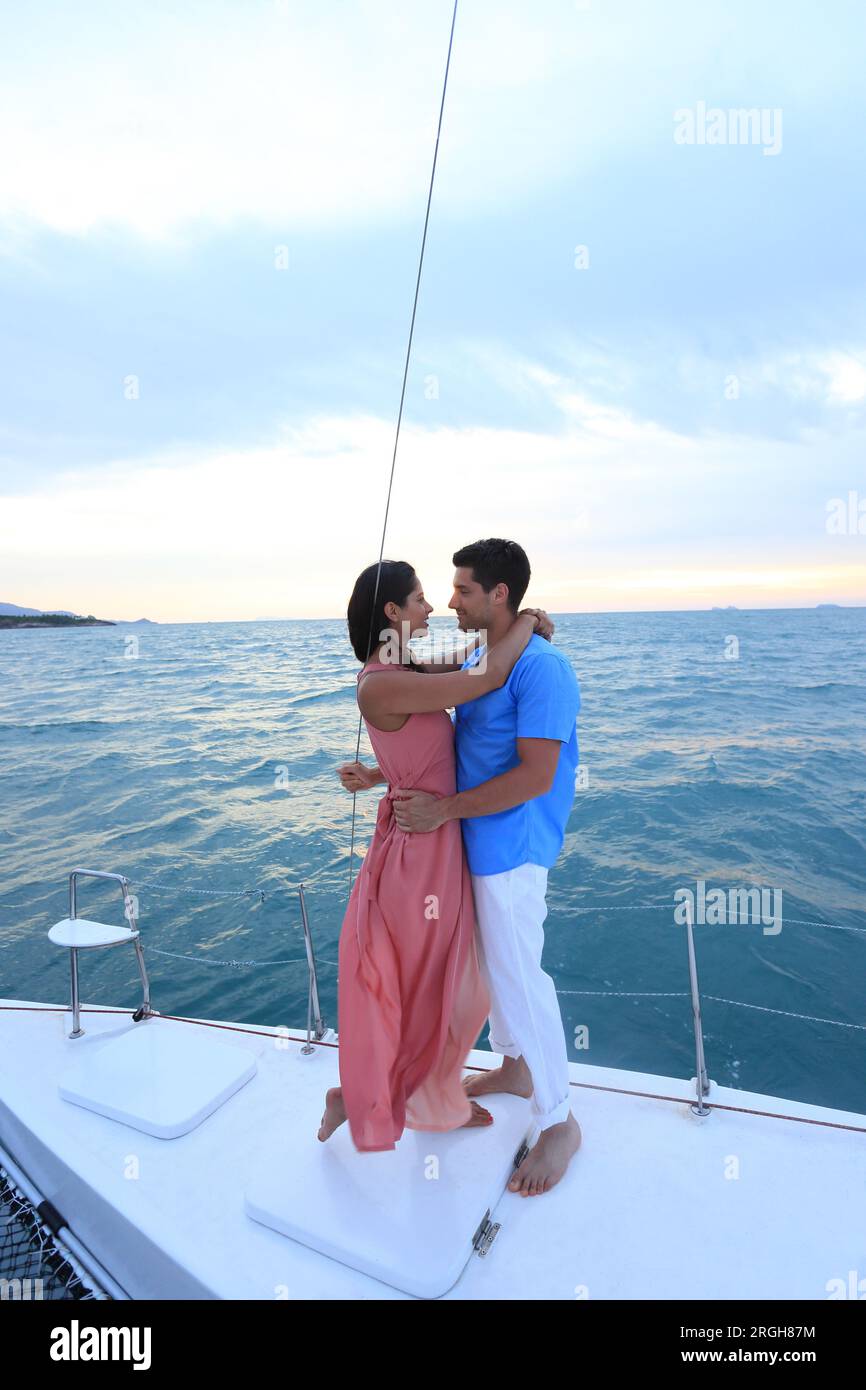 Young couple embracing on yacht at sunset Stock Photo
