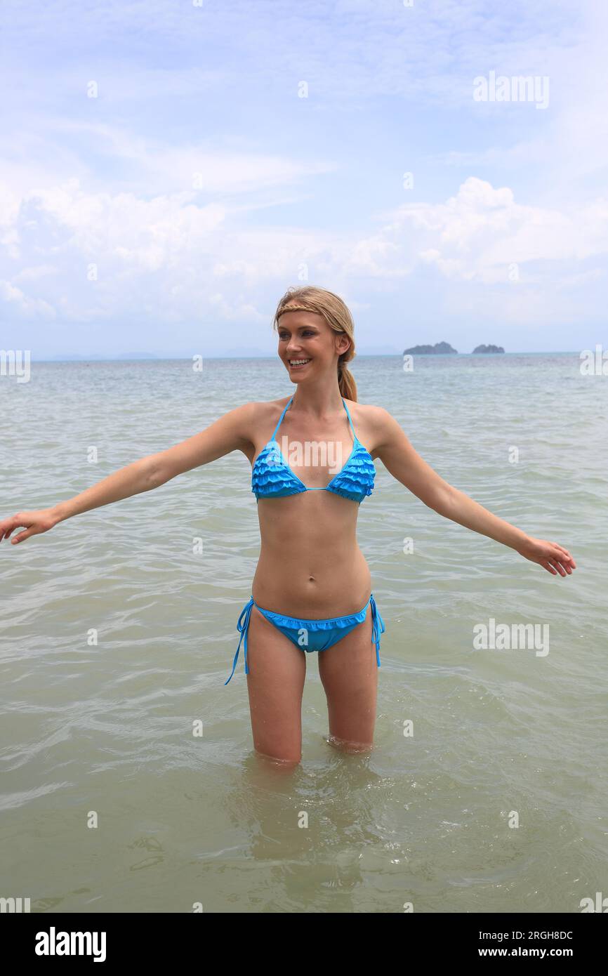 Teenager, girl in blue swimming suit on the beach Stock Photo