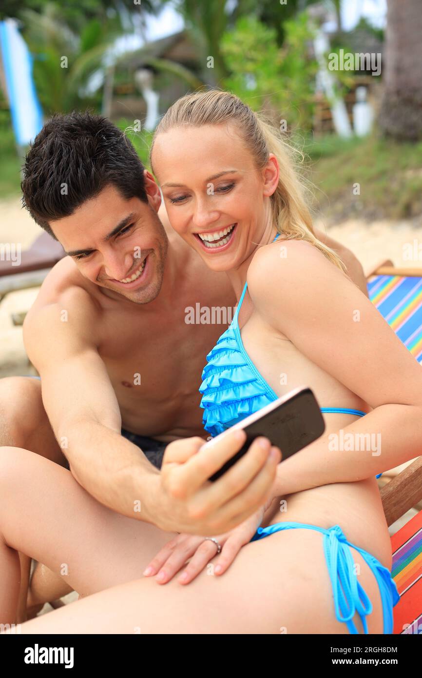 Young couple taking selfie on beach Stock Photo