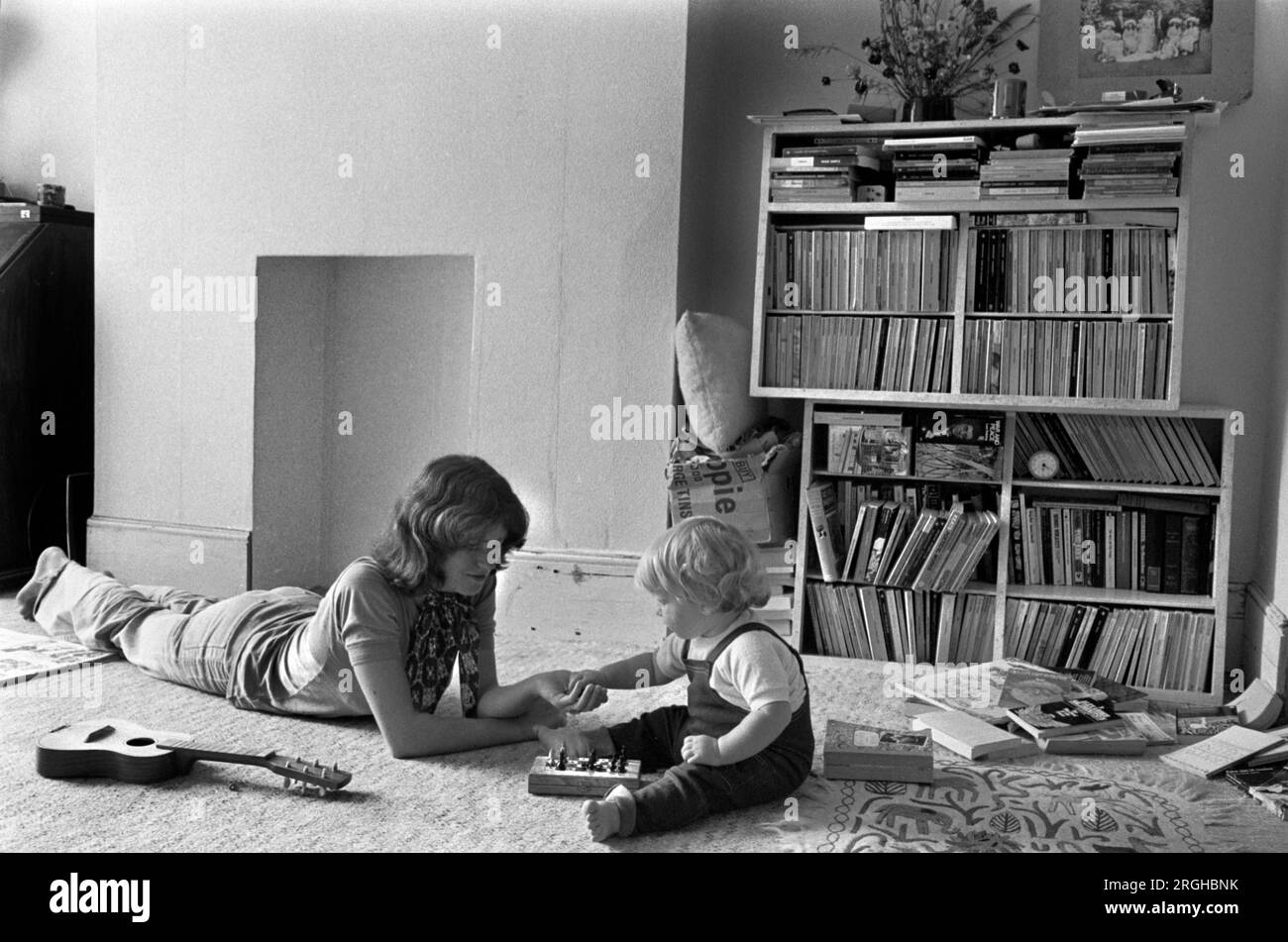 Family life interior home 1970s UK. Mother playing with baby son sitting on the floor learning. Concentrating. Mum spending quality time together with first child. Interior of living room middle class family life 1970s 1975 Southfields, South London UK HOMER SYKES Stock Photo