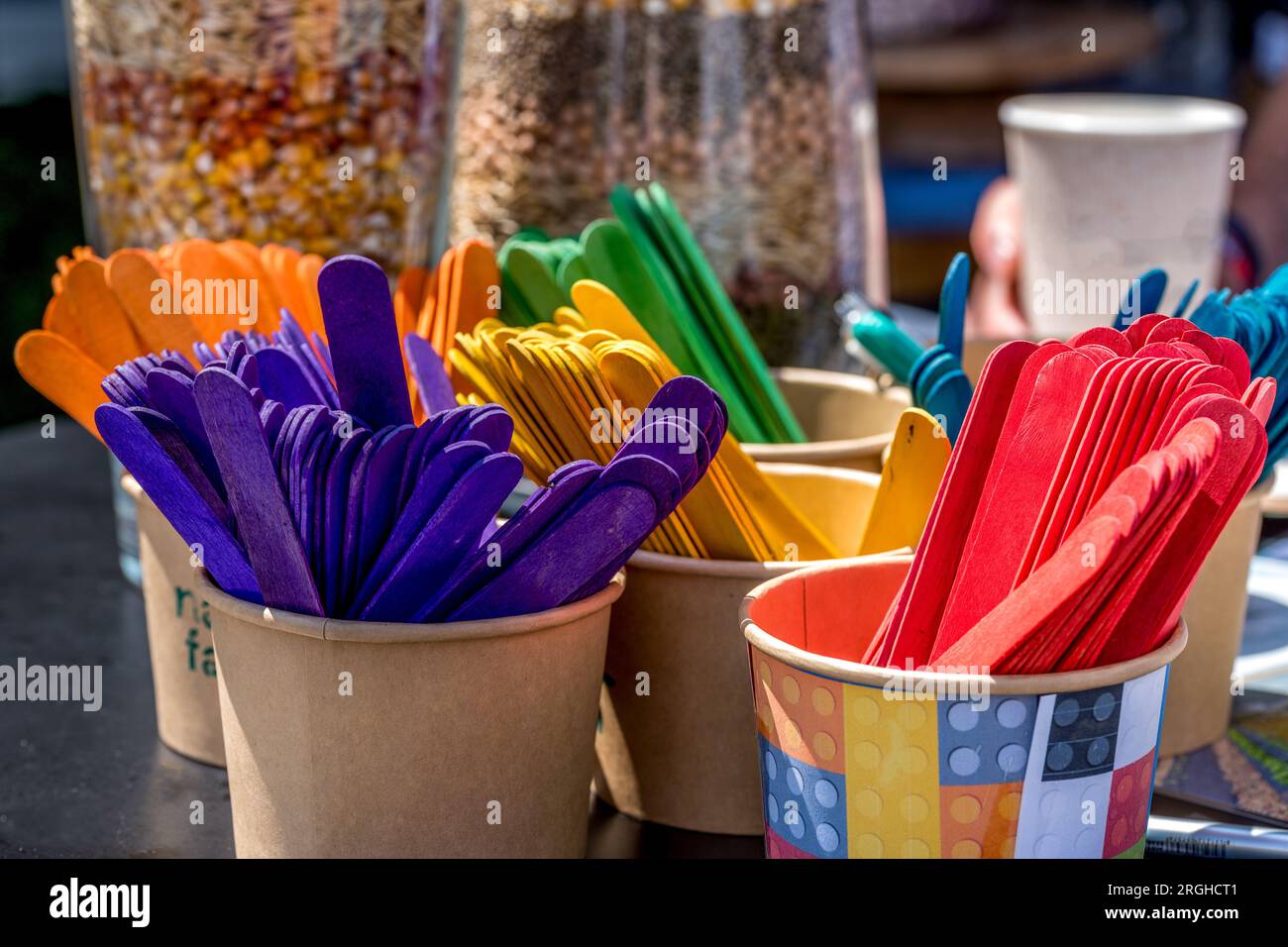 Vibrant colored wood ice cream sticks collection in paper pots Stock Photo