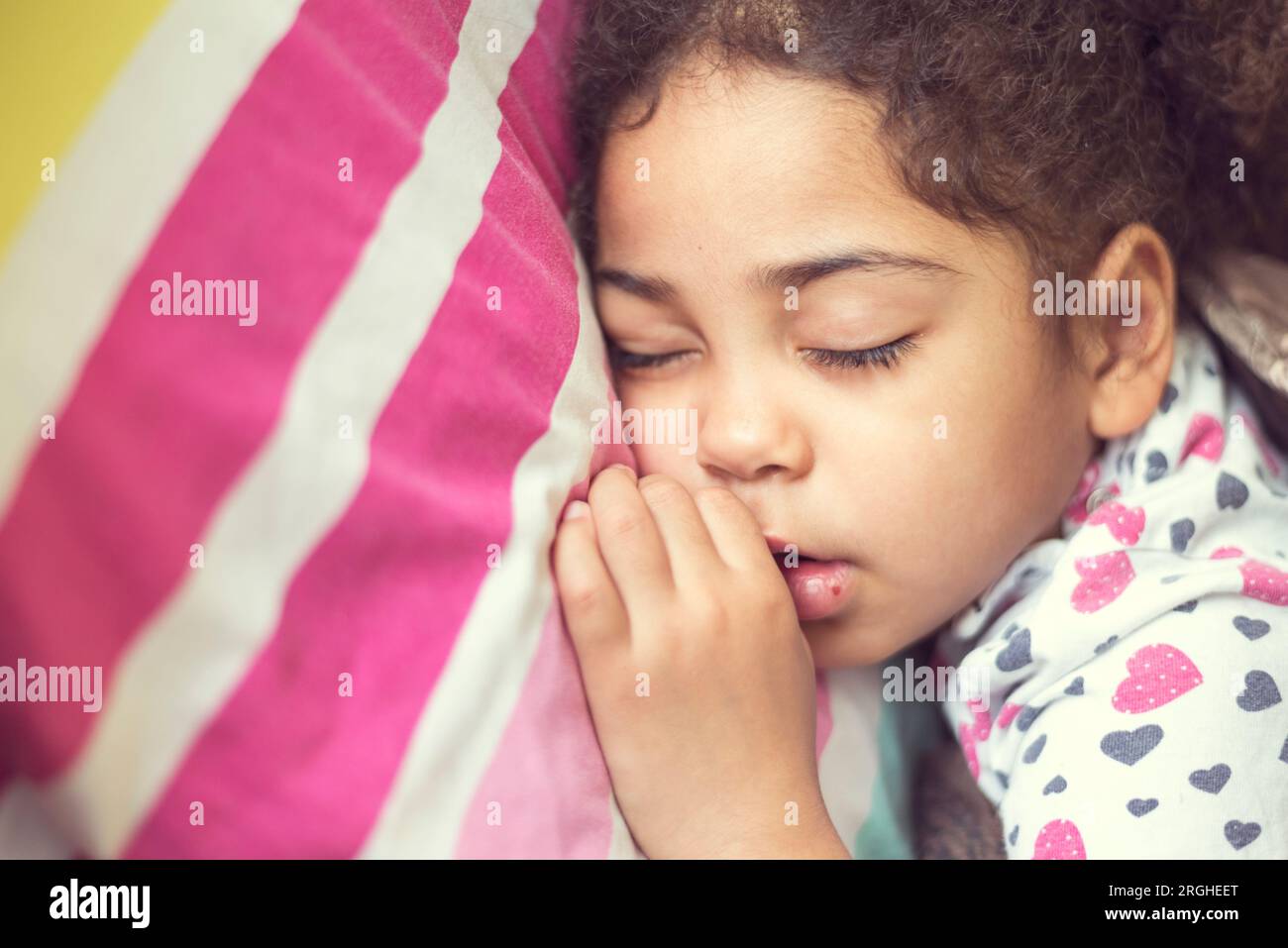 Black child sleeping in bedroom. Tired young girl kid taking a nap and