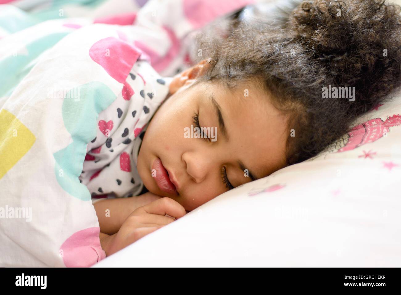 Black child sleeping in bedroom. Tired young girl kid taking a nap and