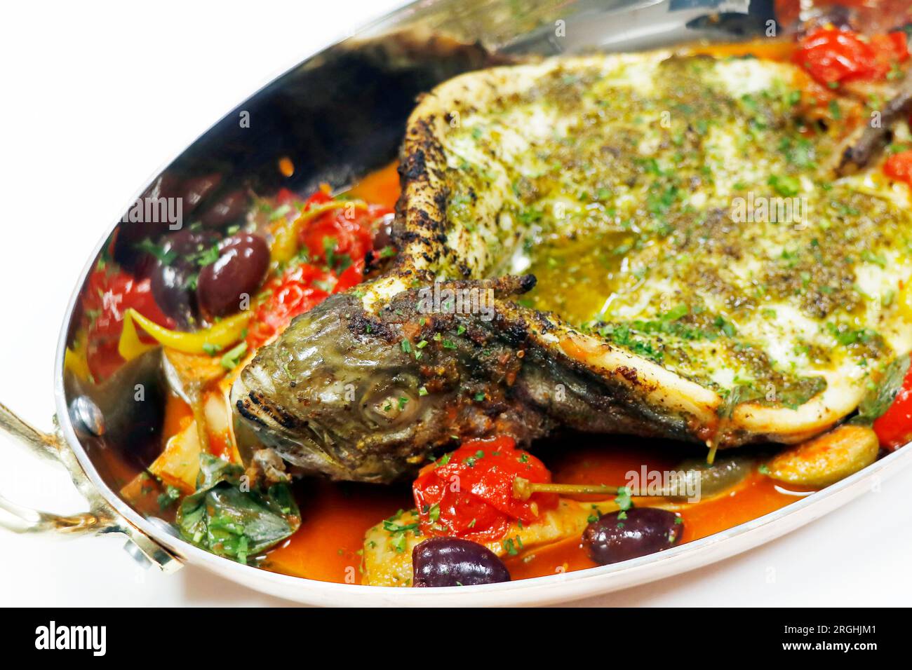 mediterranean baked sea bass fish with tomato, caper, artichoke, olive