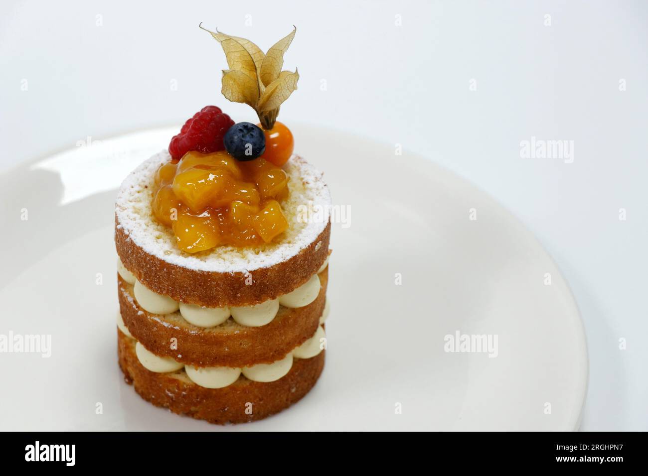 mango and coconut creamy layer cake isolated with white background Stock Photo