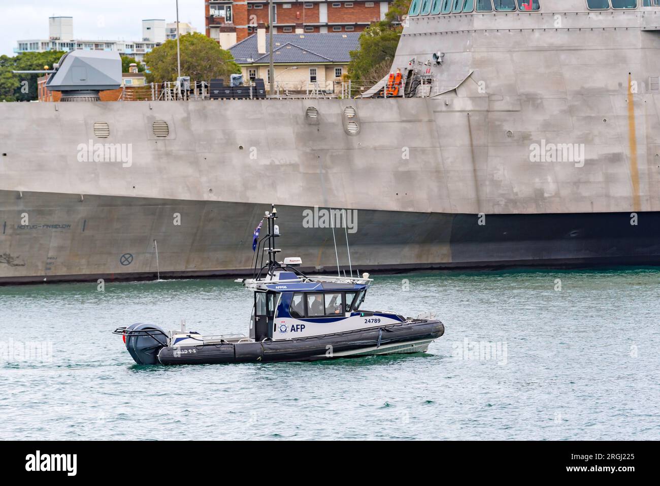 Members of the Australian Federal Police (AFP) patroling in a Naiad 9.5m boat beside the USS Canberra moored at Garden Island in Sydney, Australia Stock Photo