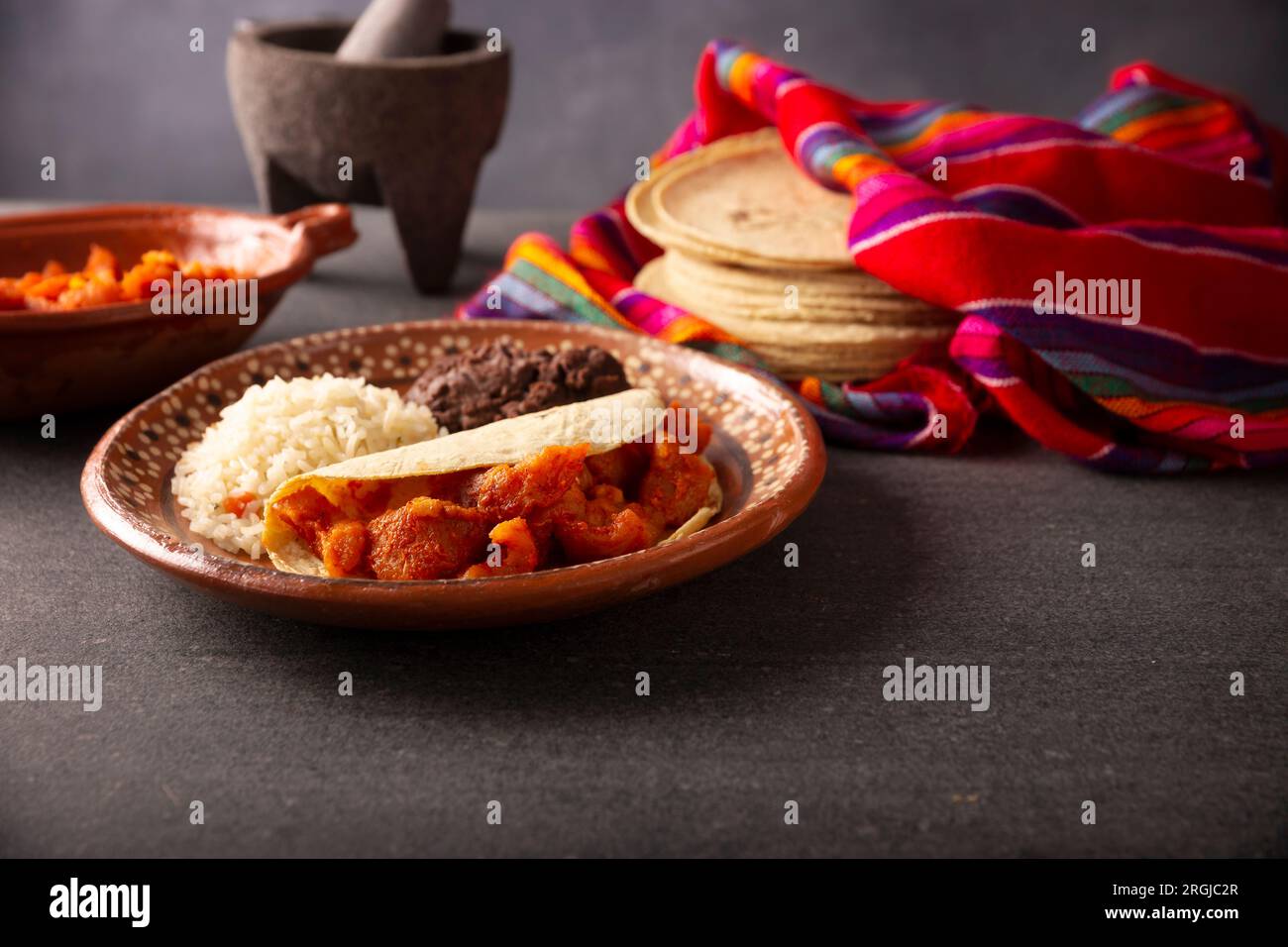 Chicharron en salsa roja. Pork rinds stewed in red sauce accompanied by rice and refried beans. Traditional homemade dish very popular in Mexico, this Stock Photo