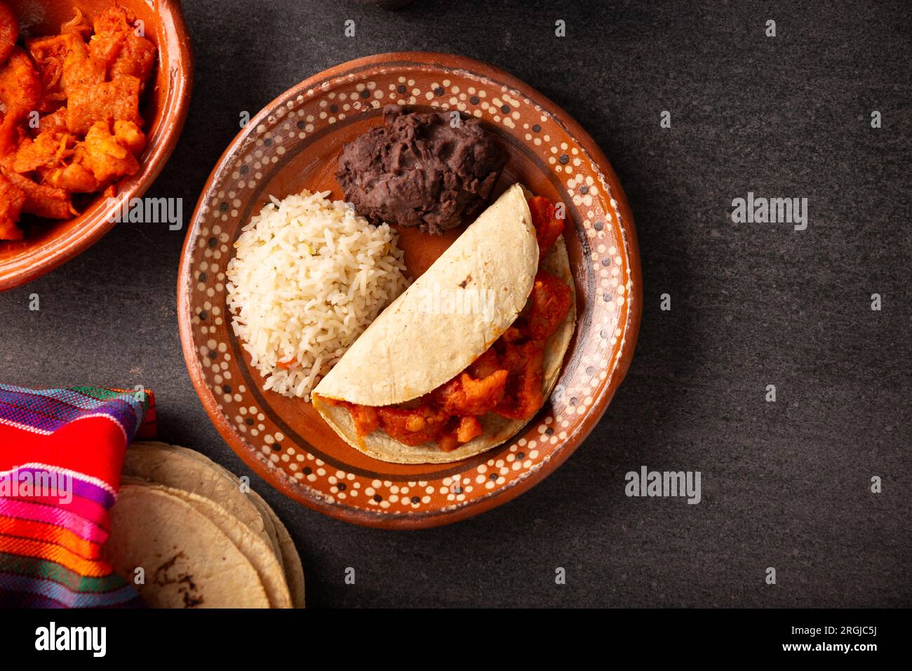 Chicharron en salsa roja. Pork rinds stewed in red sauce accompanied by rice and refried beans. Traditional homemade dish very popular in Mexico, this Stock Photo