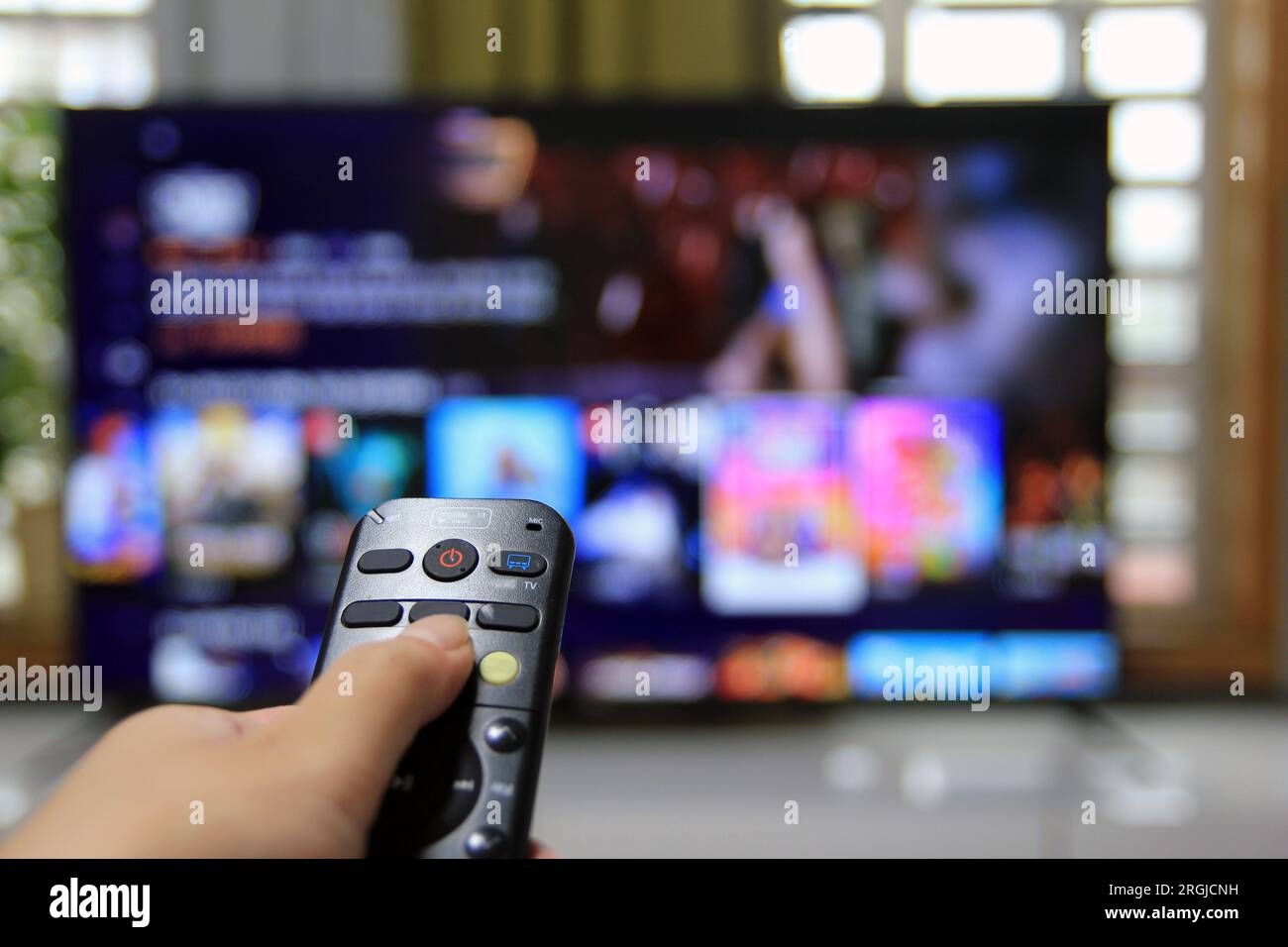 Cord Cutters Watching tv and using remote control Stock Photo