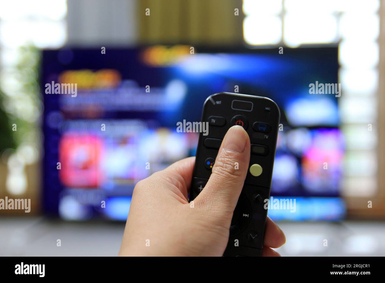 Cord Cutters Watching tv and using remote control Stock Photo