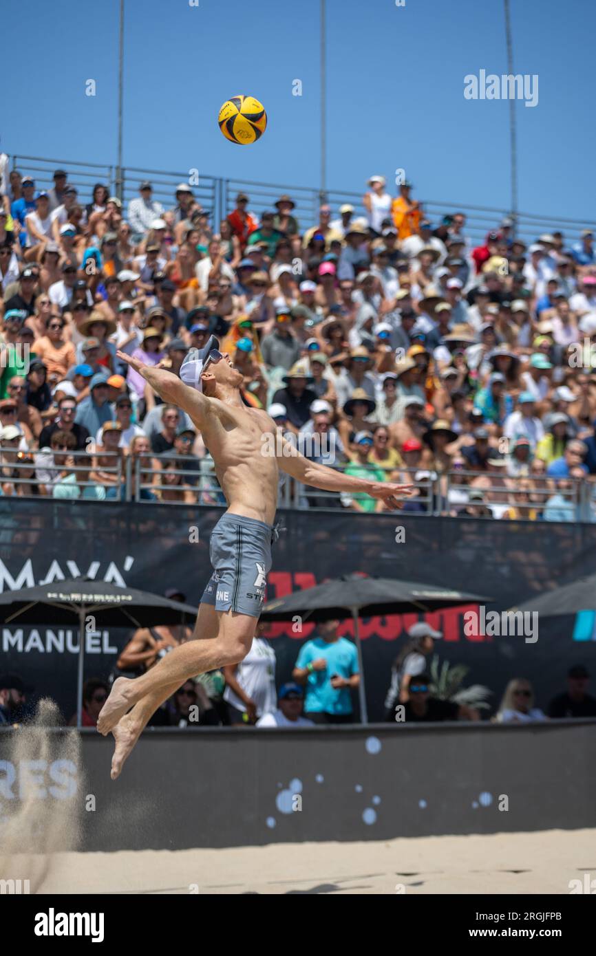 Tri Bourne serves during the AVP Hermosa Beach Open on 9 July 2023. (John Geldermann/Alamy Stock