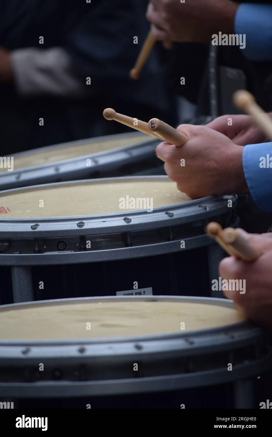 trio of drummers in marching band, each holding drumsticks Stock Photo