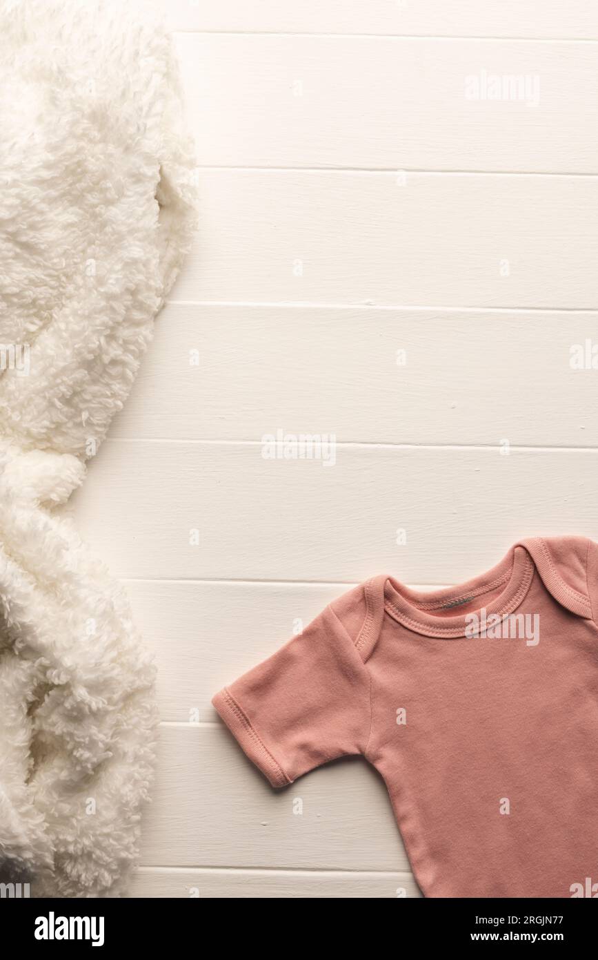 Flat lay of pink baby grow and fur rug with copy space on white board background Stock Photo