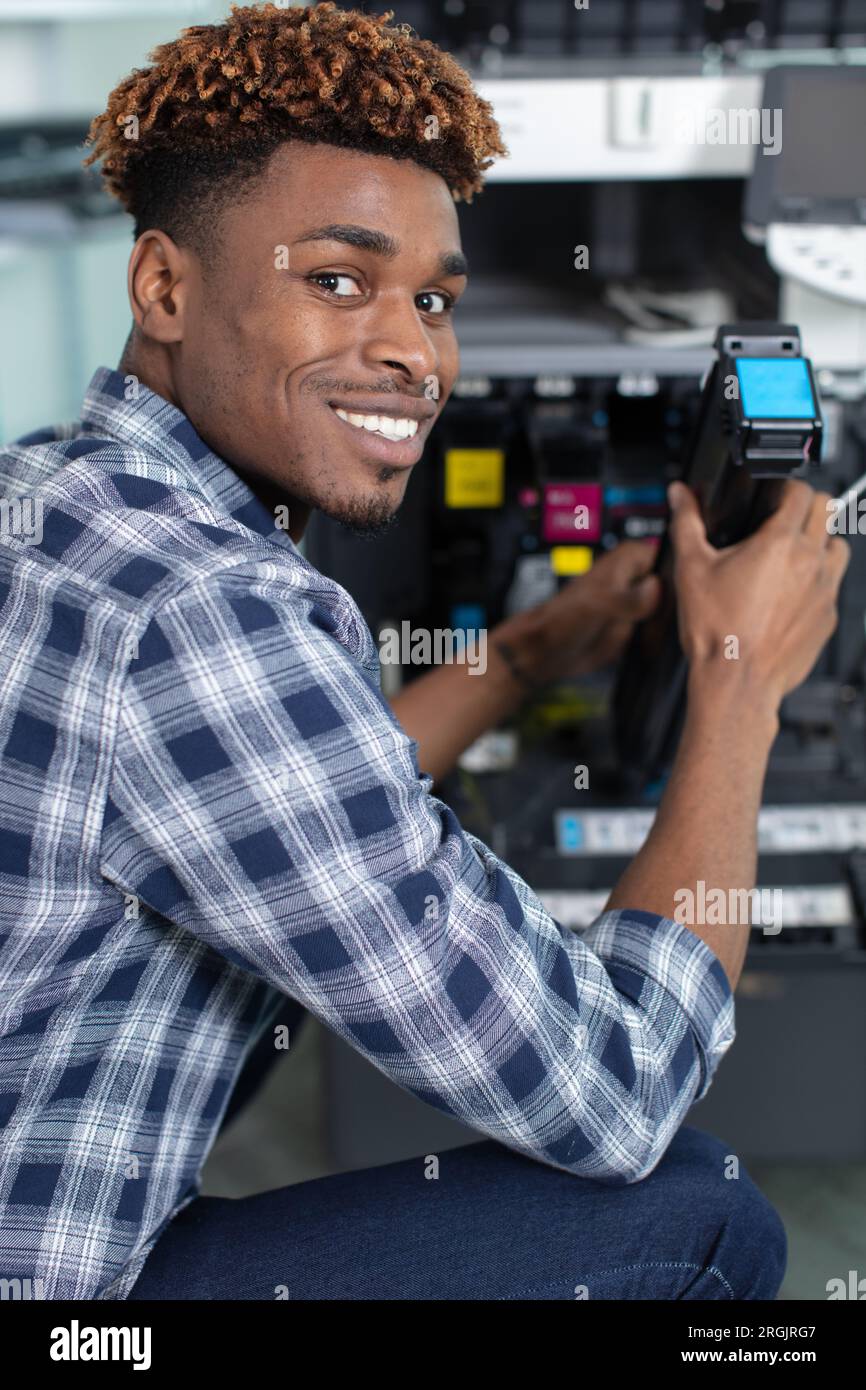 technician using a tablet to fix a printer Stock Photo