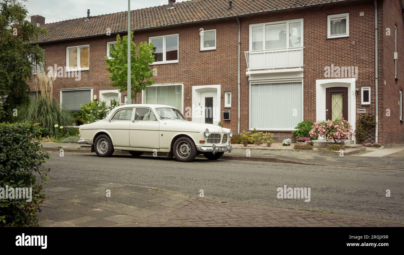 white Volvo Amazon parked on city street. 1960s classic swedish sedan staionary in residential area of dutch town Stock Photo