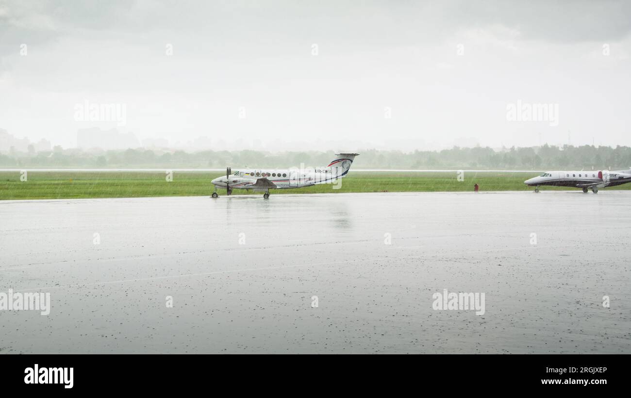 Beechcraft King Air (UR-CWA) parked on apron of Kyiv International Airport (Zhuliany) amid heavy rain. Stock Photo