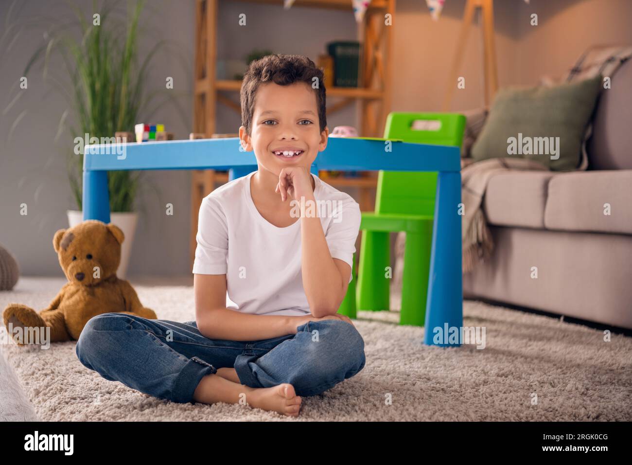 Photo of cute adorable preschool boy sitting floor in nursery room playing with many toys comfort domestic house Stock Photo