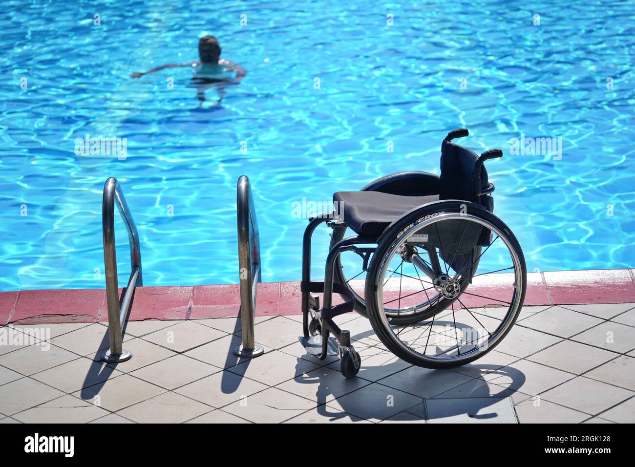 Empty wheelchair in the pool for rehabilitation of people with disabilities in water. Stock Photo