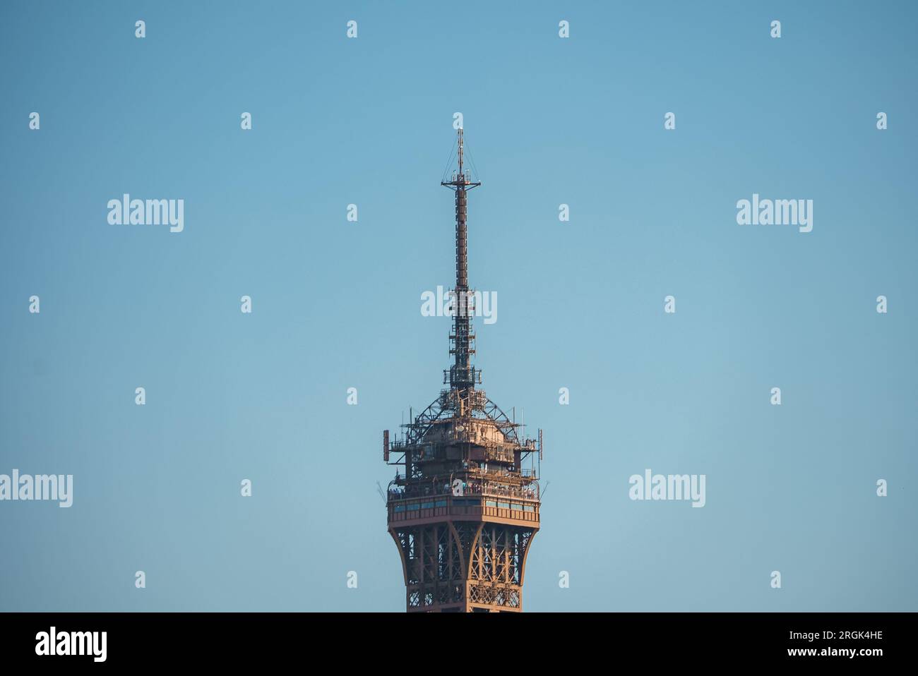 Eiffel Tower Top Close-Up Against Blue Sky Stock Photo