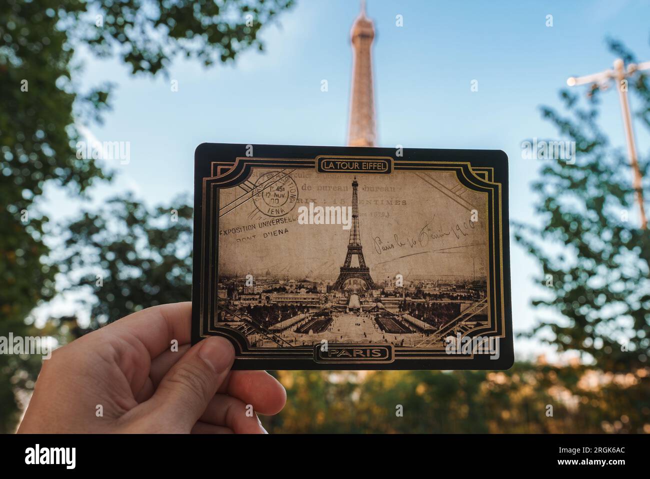 Person Holding Eiffel Tower Photo in Dark Setting Stock Photo